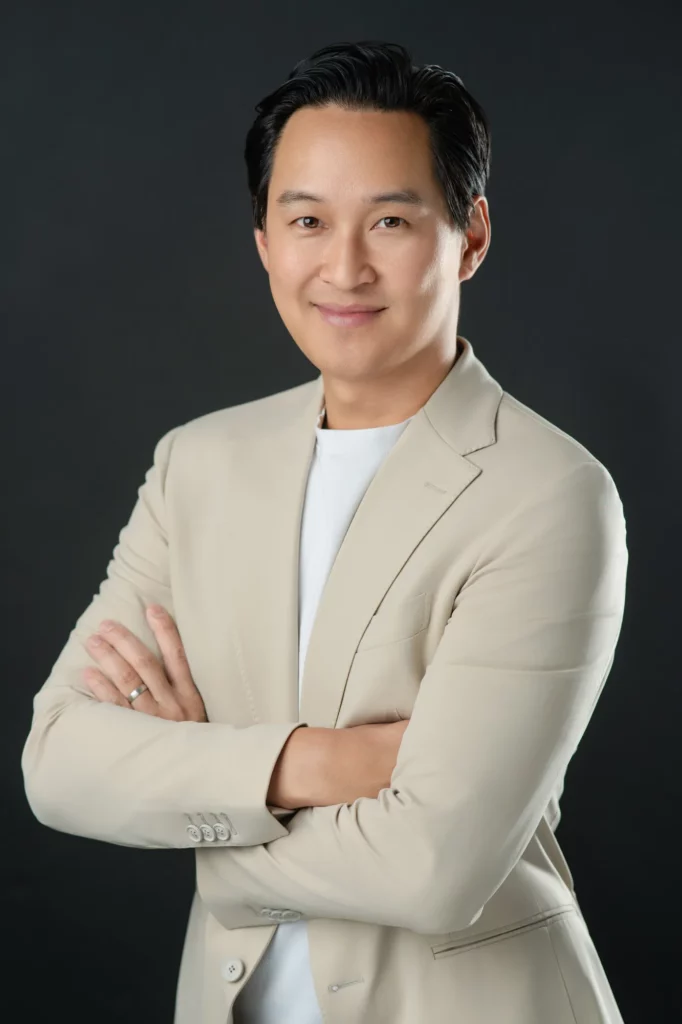 Asian male entrepreneur with arms crossed in a bright blazer