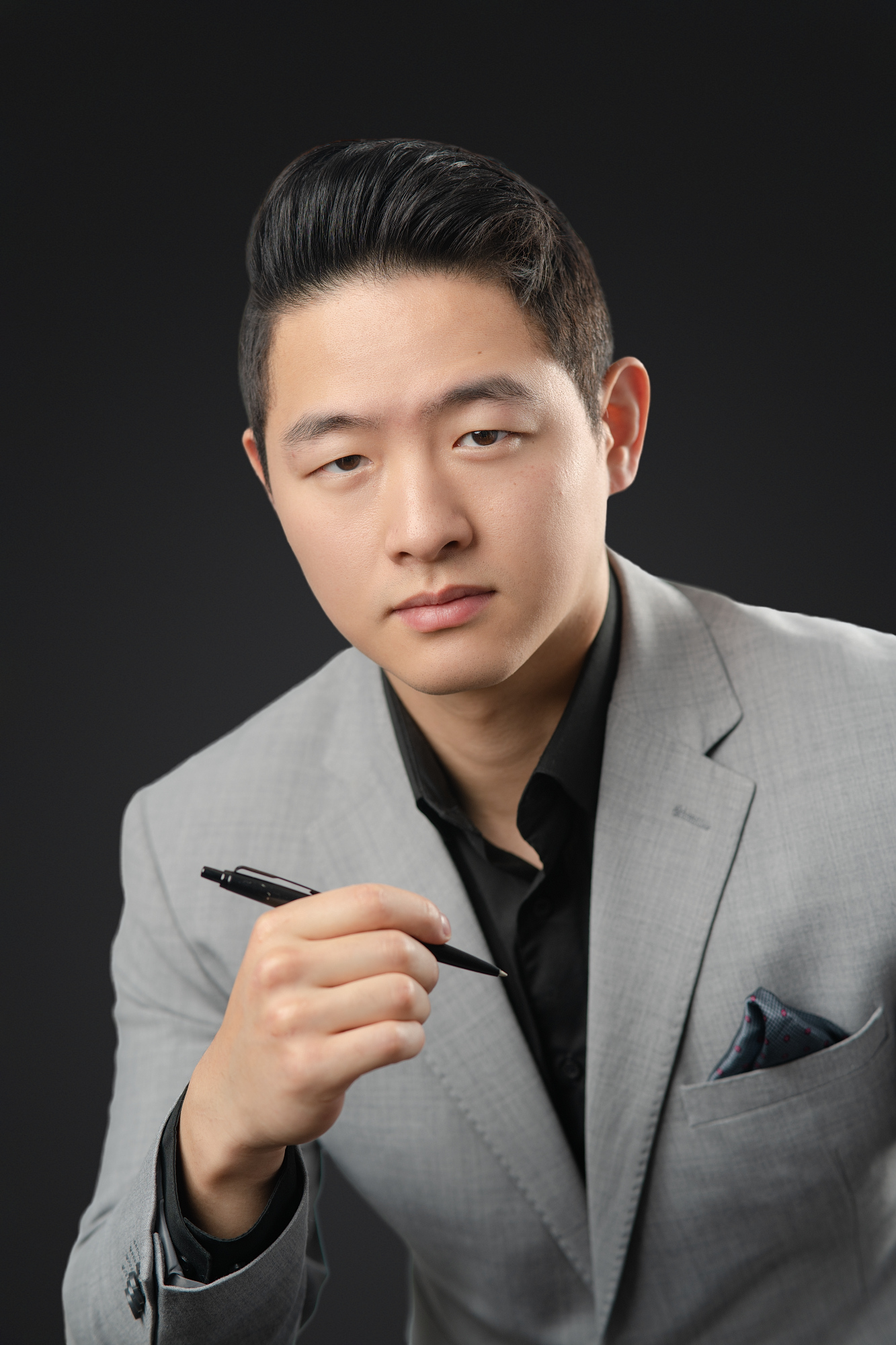 Personal branding photography shot of Coleman Chan holding a pen