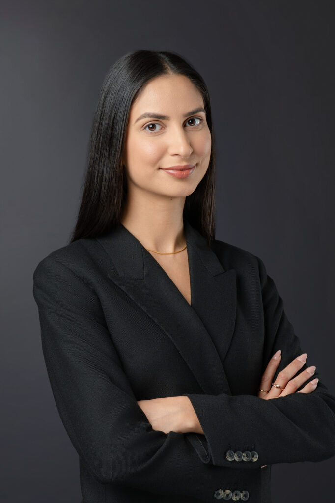 DLA Piper female lawyer with arms crossed with black background facing towards camera for a headshot