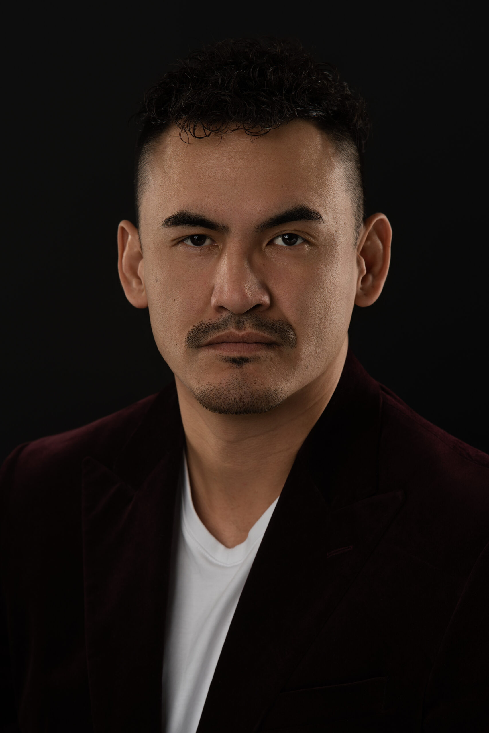 Actor headshot against a dark background