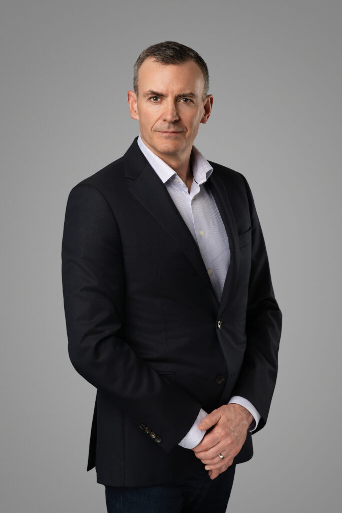 CEO Executive posing with hands clasped together for a headshot