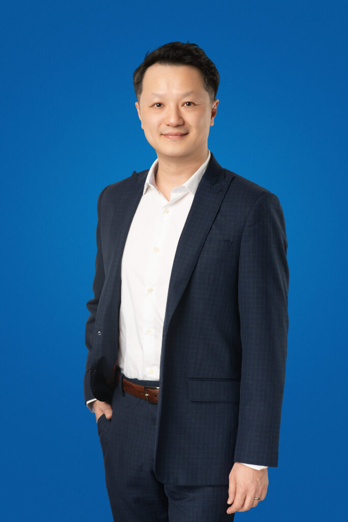 Victor Ho, President and CEO of RTC mortgage, professional corporate headshot on a blue background.