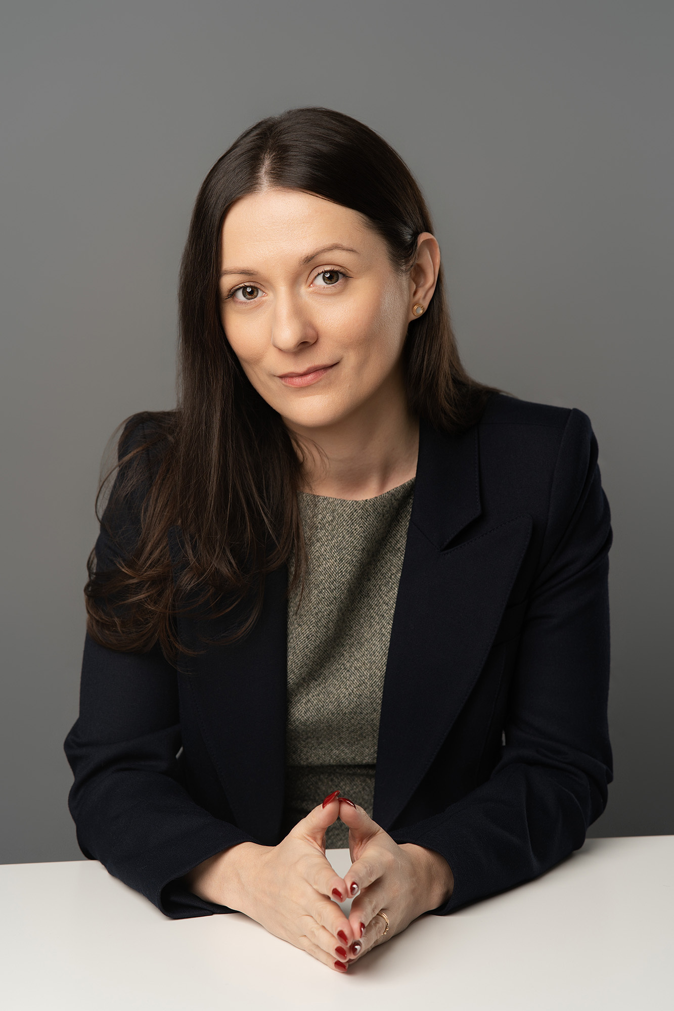 Medical professional headshot with hands together on table
