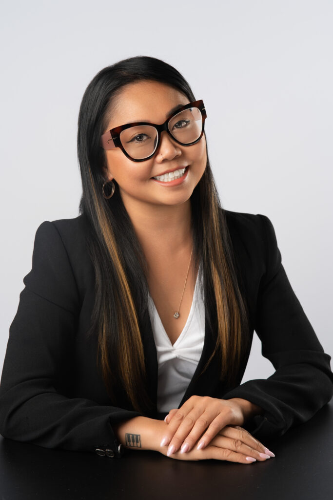 Bernadette Lagrito, posed with hands over each other on top of a table for a professional headshot in a Vancouver studio.