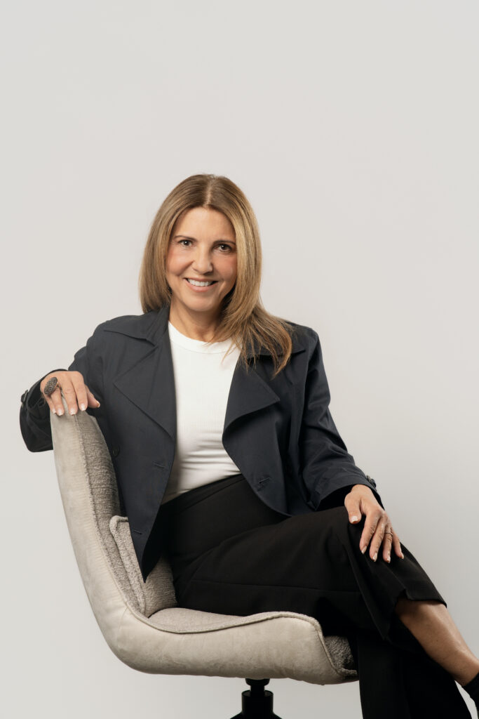 Monika Sakisian, from SGH Design Partners posing on a chair for a headshot.