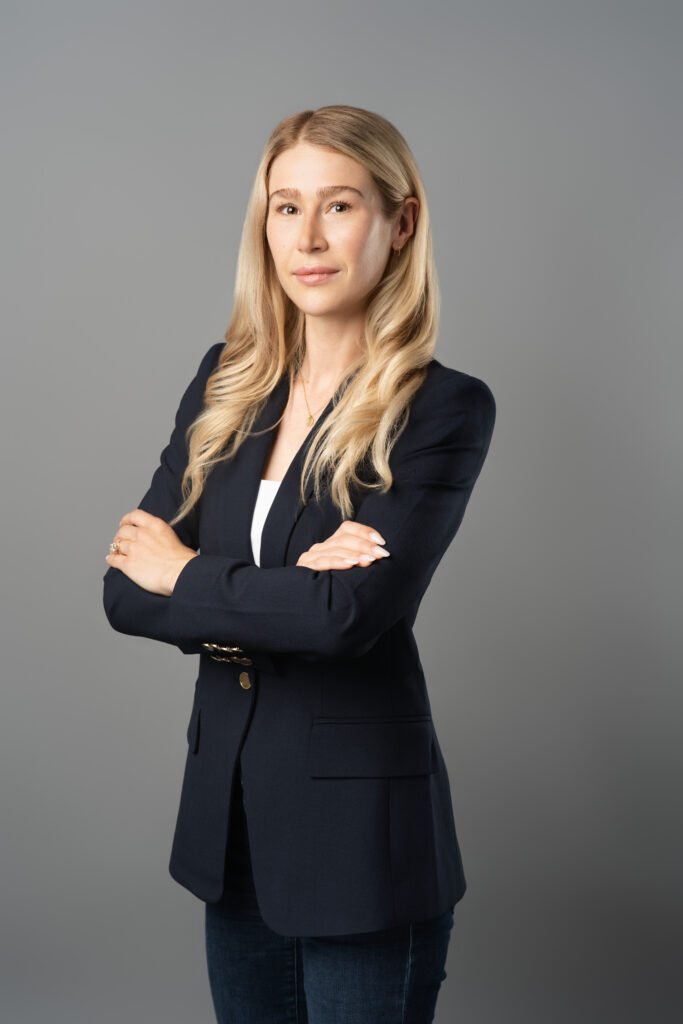 Female executive, Vice President from BMO Capital Markets posing with crossed arms for a headshot in Vancouver at HeadshotPhoto.ca's studio